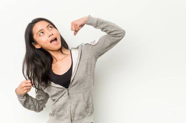 Genç fitness Çinli kadın zaferden sonra yumruğunu kaldırıyor, kazanan konsept.