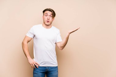 Kafkasyalı genç yalnız poz veriyor. Palmiye üzerinde fotokopi alanı tutmaktan etkilenmiş..