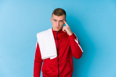 Genç sporcu parmağıyla tapınağı işaret ediyor, düşünüyor, bir göreve odaklanıyor..