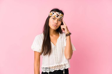 Genç Çinli hippi, tapınağı parmağıyla göstererek bir göreve odaklandı..