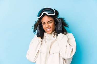 Genç Afrikalı Amerikalı kayakçı kadın kulaklarını elleriyle kapatıyor..