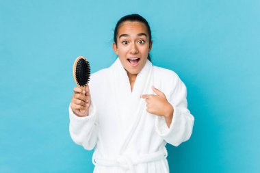 Saç fırçası tutan genç bir Kızılderili kendini göstererek şaşırdı, geniş bir gülümsemeyle..