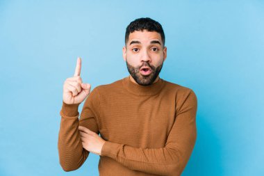 Mavi arka planda yaşayan genç bir latin adamın harika bir fikri, yaratıcılık kavramı var..