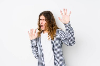 Genç, uzun saçlı bir adam yaklaşan bir tehlike yüzünden şoka girmiş gibi görünüyor.