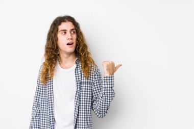 Genç, uzun saçlı bir adam parmak kadar uzakta, yalnız poz veriyor, gülüyor ve kaygısız..