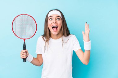 Badminton oynayan beyaz kadın hoş bir sürprizle karşılaştı, heyecanlandı ve el kaldırdı..