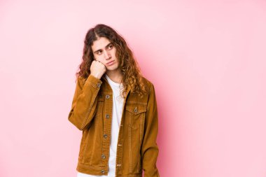 Genç, uzun saçlı, yalnız poz veren üzgün ve düşünceli bir adam, fotokopi alanına bakıyor..