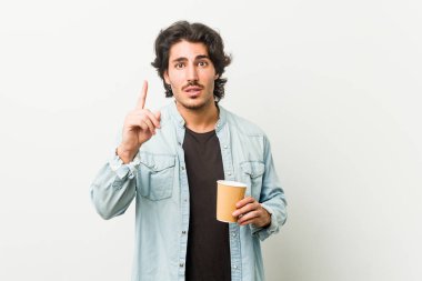 Young cool man drinking a coffee having an idea, inspiration concept.