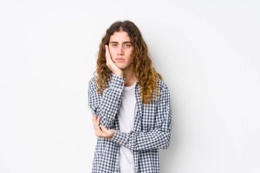 Uzun saçlı, yalnız poz veren, sıkılmış, yorgun ve dinlenmeye ihtiyacı olan genç bir adam..