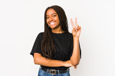 Beyaz arka planda izole edilmiş genç Afrikalı Amerikalı kadın iki numarayı parmaklarıyla gösteriyor..