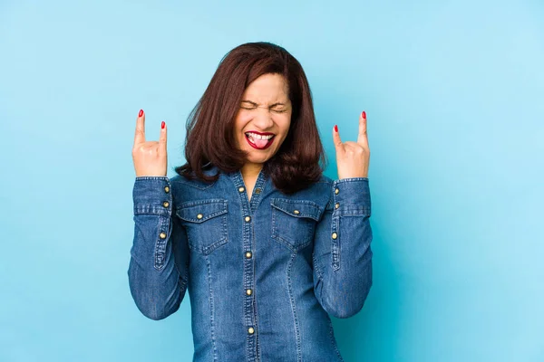 Middelbare Leeftijd Latijn Vrouw Geïsoleerd Een Blauwe Achtergrond Tonen Rock — Stockfoto