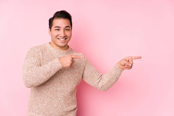 Joven Hombre Curvilíneo Posando Fondo Rosa Aislado Excitado Apuntando Con — Foto de Stock