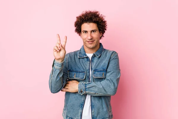 卷曲成熟的男人 穿着粉色背景的斜纹棉布夹克 手指头是二号 — 图库照片