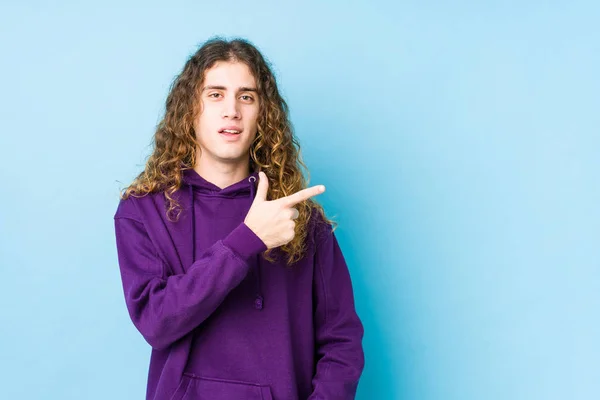 Homem Cabelos Longos Posando Isolado Sorrindo Apontando Para Lado Mostrando — Fotografia de Stock