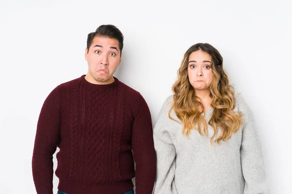 Casal Jovem Posando Fundo Branco Encolhe Ombros Olhos Abertos Confusos — Fotografia de Stock