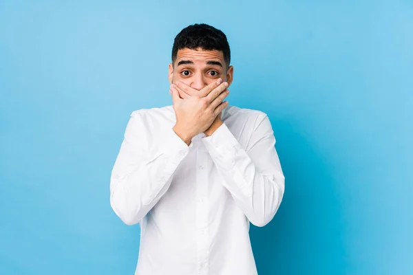 Ung Latin Man Mot Blå Bakgrund Isolerad Chockad Täcker Munnen — Stockfoto