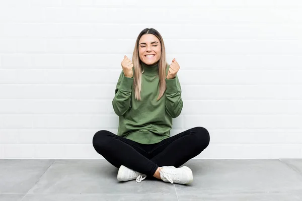 Jovem Caucasiana Sentada Chão Levantando Punho Sentindo Feliz Bem Sucedida — Fotografia de Stock