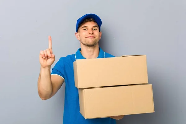 Junger Mann Liefert Pakete Mit Zeigefinger Aus — Stockfoto