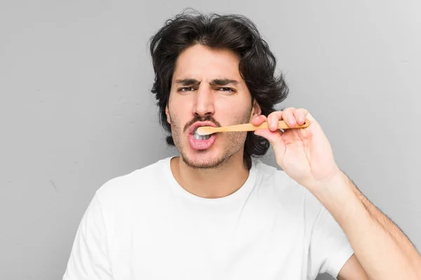 Ung Kaukasier Man Rengöra Sina Tänder Med Tandborste Isolerad Grå — Stockfoto