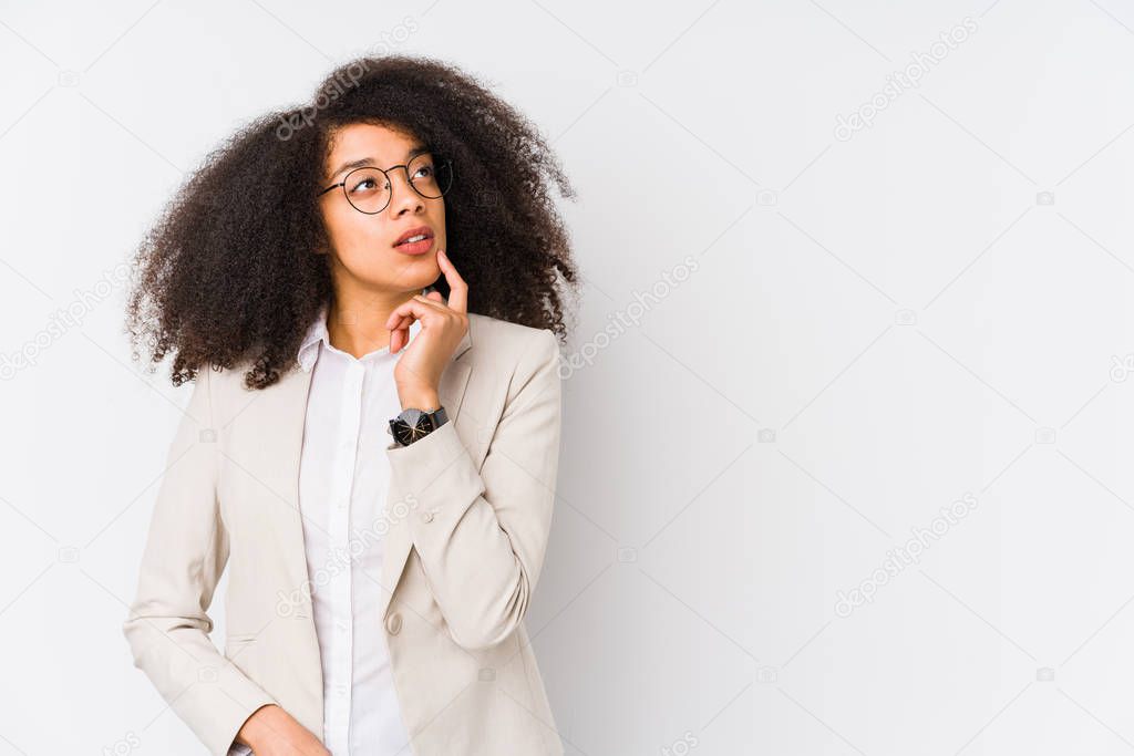 Young african american business woman looking sideways with doubtful and skeptical expression.