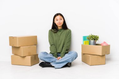 Young chinese woman moving to a new home dreaming of achieving goals and purposes