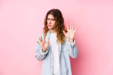 Uzun saçlı adam yalnız poz veriyor. İğrenme belirtisi gösteren birini reddediyor..