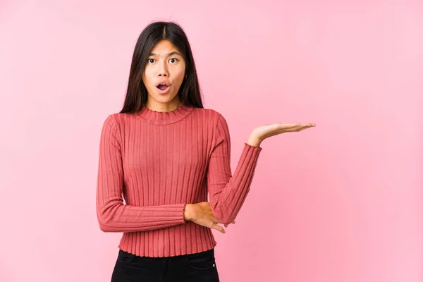 Jovem Chinesa Posando Isolado Impressionado Segurando Espaço Cópia Palma Mão — Fotografia de Stock