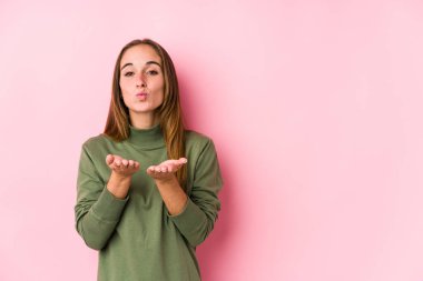 Kafkasyalı genç bir kadın yalıtılmış, katlanmış dudaklar ve hava öpücüğü yollamak için avuç içleri tutuyor..