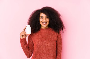 Vitaminlerini tutan genç afro kadın vitaminli, gülümseyen ve neşeli bir afro kadın..