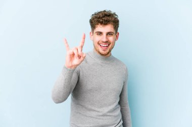 Sarışın, kıvırcık saçlı, beyaz tenli bir adam izole edilmiş boynuzlarını devrim hareketi olarak gösteriyor..