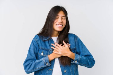 Genç Asyalı kadın gülüyor ellerini kalbe koyuyor, mutluluk kavramı..