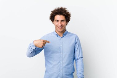 Young curly mature man wearing an elegant shirt person pointing by hand to a shirt copy space, proud and confident clipart