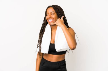 Genç Afro-Amerikan spor kadını izole edilmiş, parmaklarıyla bir cep telefonu hareketi gösteriyor..