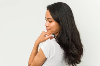 Beyaz arka planda poz veren genç Çinli kadın.