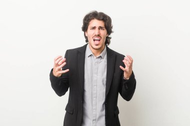 Genç bir iş adamı beyaz bir geçmişe karşı öfkeyle bağırıyor..