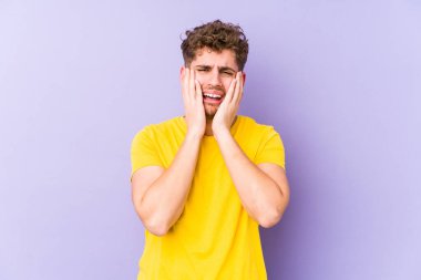 Sarışın, kıvırcık saçlı, beyaz tenli bir adam sızlanıyor ve ağlıyor..