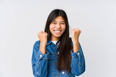 Genç Asyalı kadın gamsız ve heyecanlı bir şekilde tezahürat yapıyor. Zafer konsepti.