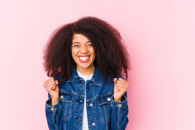 Genç Afrikalı Amerikalı kadın gamsız ve heyecanlı bir şekilde tezahürat yapıyor. Zafer konsepti.