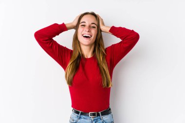 Yalnız poz veren beyaz bir kadın ellerini başının üstünde tutarak neşeli bir şekilde gülüyor. Mutluluk kavramı.