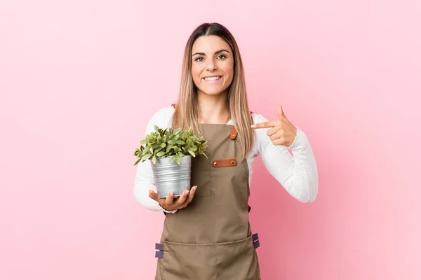 Jovem Jardineira Segurando Uma Pessoa Planta Apontando Mão Para Espaço — Fotografia de Stock