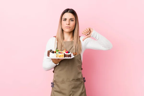 Jovem Padeira Segurando Doces Mostrando Gesto Antipatia Polegares Para Baixo — Fotografia de Stock