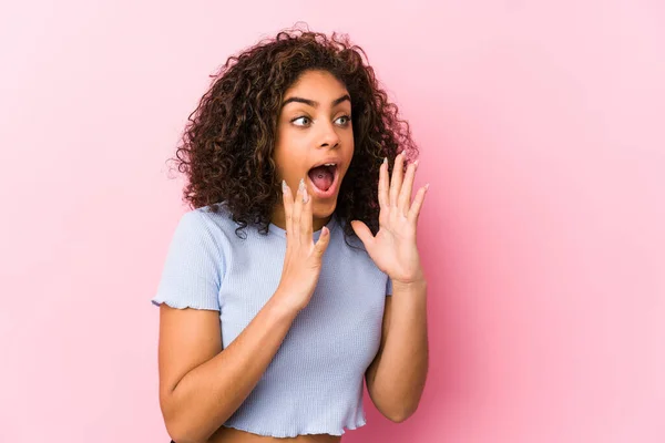 Junge afrikanisch-amerikanische Frau vor rosa Hintergrund schreit lo — Stockfoto