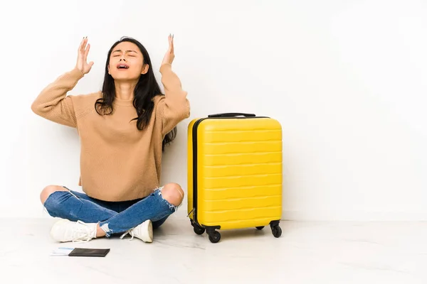 若い中国人旅行者の女性の床にスーツケースを空に叫んで隔離され 上を向いて座って — ストック写真