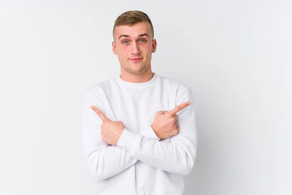Junger Kaukasischer Mann Auf Weißem Hintergrund Zeigt Seitwärts Versucht Zwischen — Stockfoto