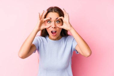 İzole edilmiş kayak kıyafetleri giyen genç beyaz kadın başarı fırsatı bulmak için gözlerini açık tutuyor..