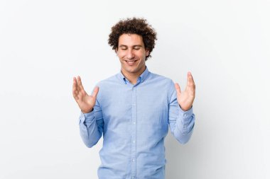 Genç, kıvırcık, olgun, zarif bir gömlek giyen neşeli, çok gülen bir adam. Mutluluk kavramı.
