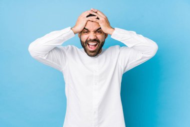 Mavi bir geçmişi olan genç bir latin adam neşeli bir şekilde el ele tutuşarak gülüyor. Mutluluk kavramı.