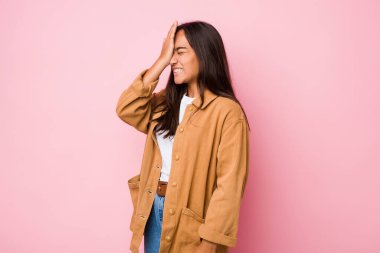 Genç melez Hintli kadın bir şeyi unutuyor. Alnına avuç içi ve kapalı gözlerle vuruyor..