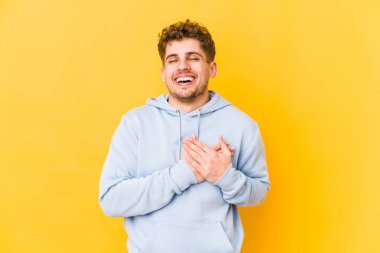  Gülüyor, ellerini kalbe koyuyor, mutluluk kavramını koruyor.