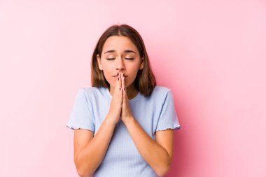 Kafkasyalı genç bir kadın kayak kıyafetleri giyiyor. El ele tutuşup dua ediyor. Kendine güveniyor..